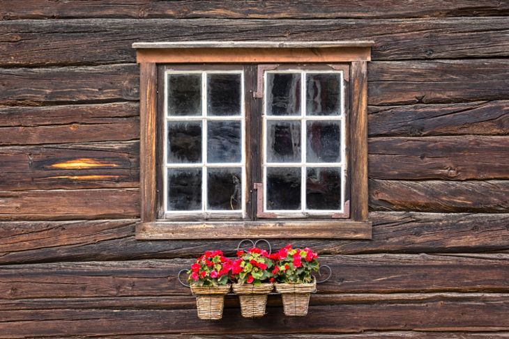 窓の前にベゴニアがある木造住宅のとても素敵な窓を見る