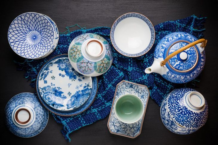 Класическите сини спално бельо и посуда добавят цвят към иначе неутралното пространство.