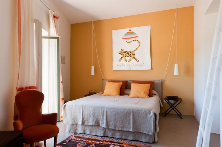 Спалня с оранжева стена и оранжеви възглавници