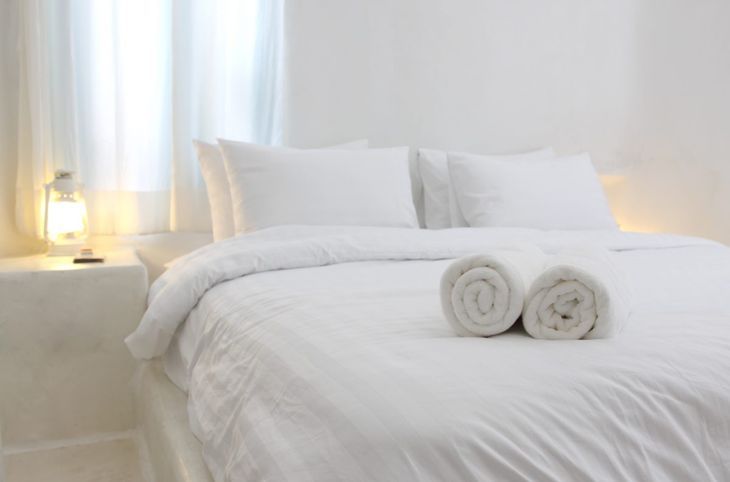 Спалня с бели стени, легло и мебели