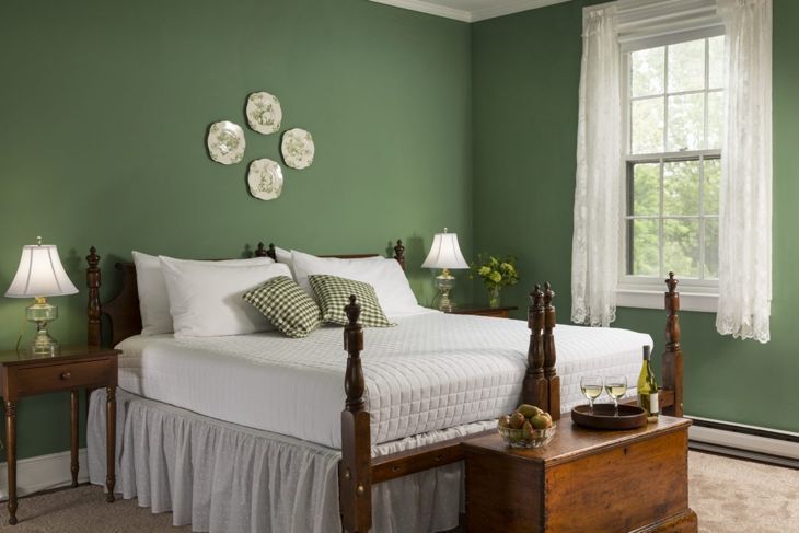 緑の壁と木製のベッド付きのベッドルーム