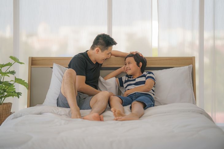 баща и малък син говорят в леглото преди лягане