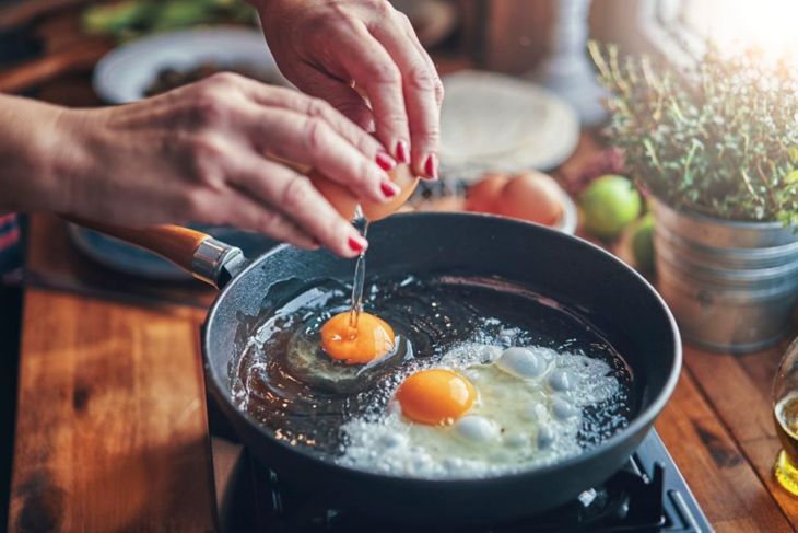 Пържене на яйце в тиган в домашна кухня