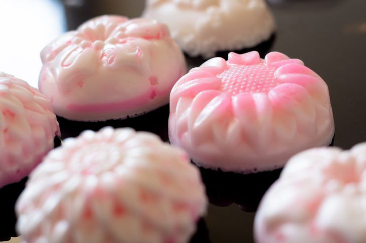 Готови домашни сапунени кексчета в розово и бяло върху стъклена повърхност. Това хоби домашен бизнес е чудесен начин да направите ароматерапия, естествени сапуни, които са по-здравословни