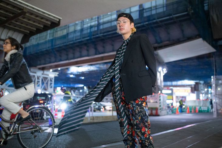 ТОКИО, ЯПОНИЯ - 22 МАРТ: Гост се вижда с огромна раирана вратовръзка, панталони с цветя, черен блейзър и шапка по време на Седмицата на модата на Amazon TOKYO 2019 A/W на 22 март 2019 г. в Токио, Япония.