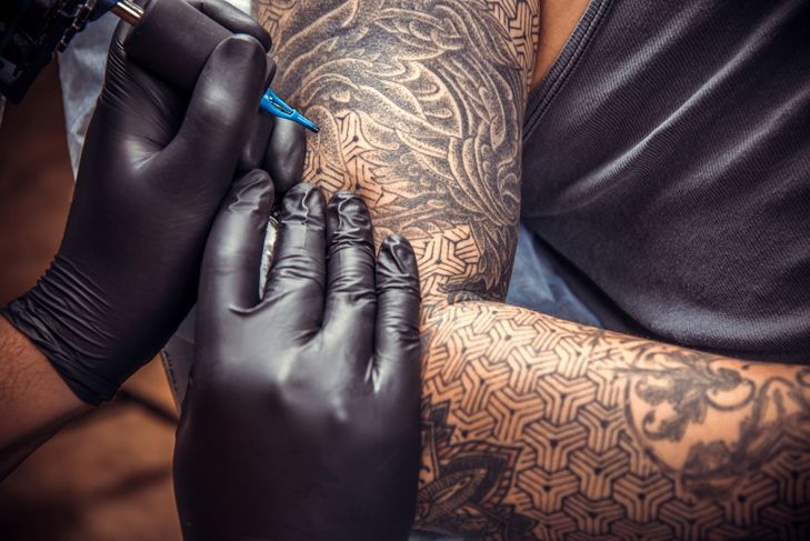 Майстор по татуиране в студио за татуировки./Професионален татуист работи в студио