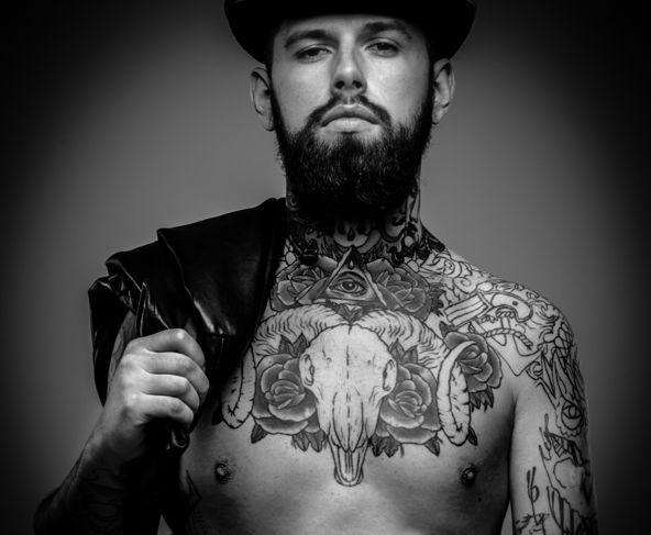 Красив сериозен мъж с татуирано тяло