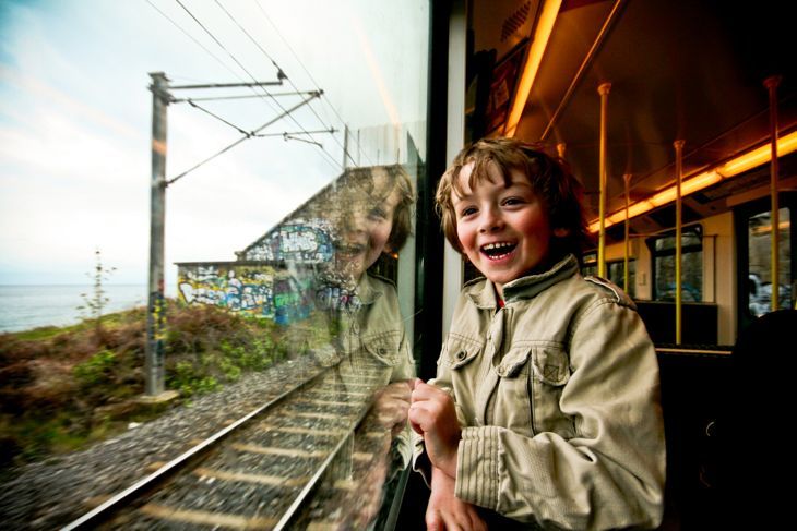 Много развълнувано младо момче гледа през прозореца на влака.
