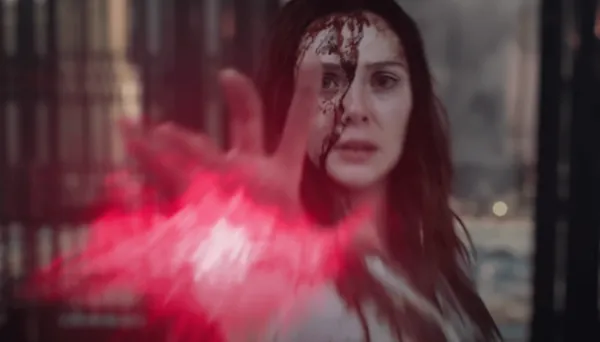 血まみれの顔と手から赤いエネルギーが出るスカーレット・ウィッチ役のエリザベス・オルセン